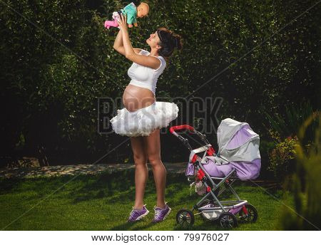 Beautiful pregnant woman having fun in garden 