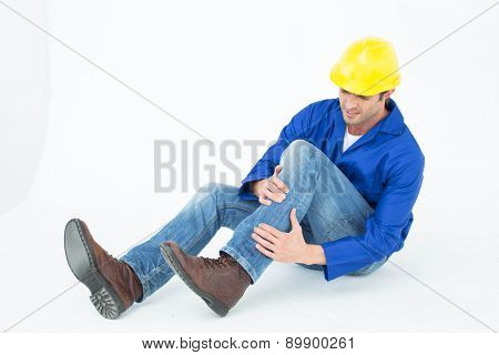 Full length of architect suffering from knee pain against white background