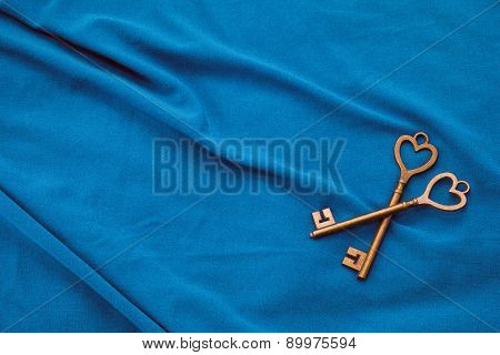 Two vintage keys on blue fabric