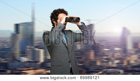 Businessman in search for opportunities on the top of a skyscraper