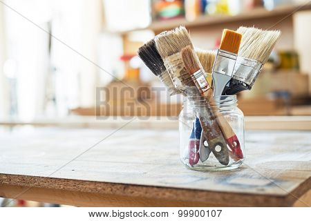 Paint brushes on the table in a workshop.