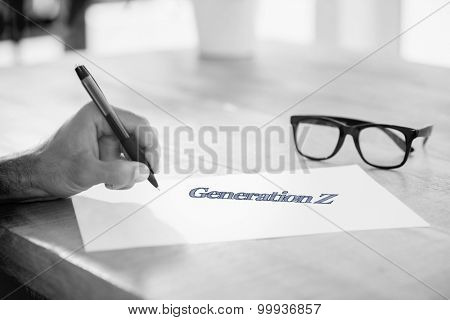 The word generation z against side view of hand writing on white page on working desk