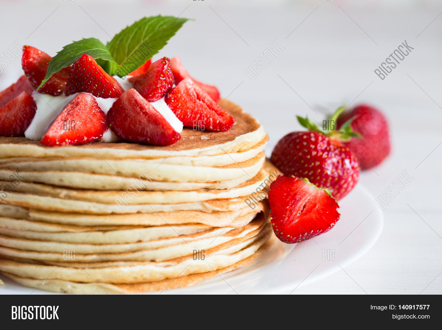 delicious pancakes with strawberry on wooden background