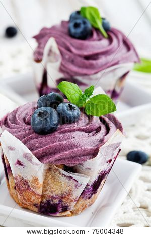 blueberry cupcakes with frosting, blueberries and mint leaves