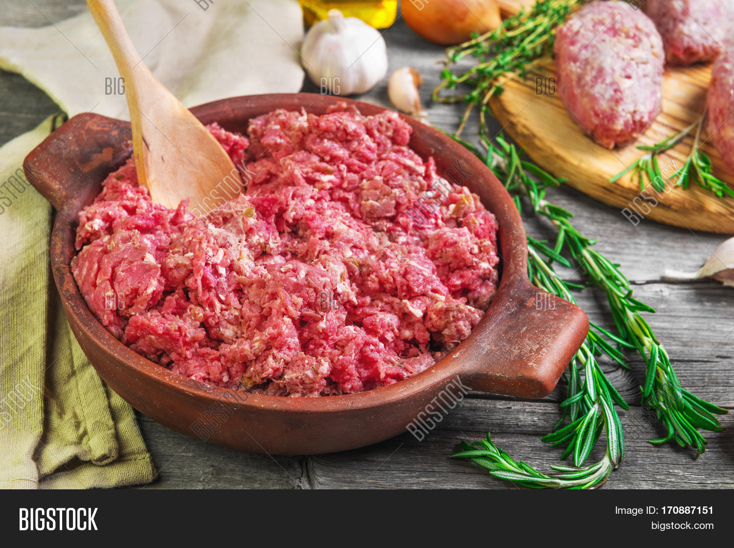 minced meat in a bowl four meat patties.