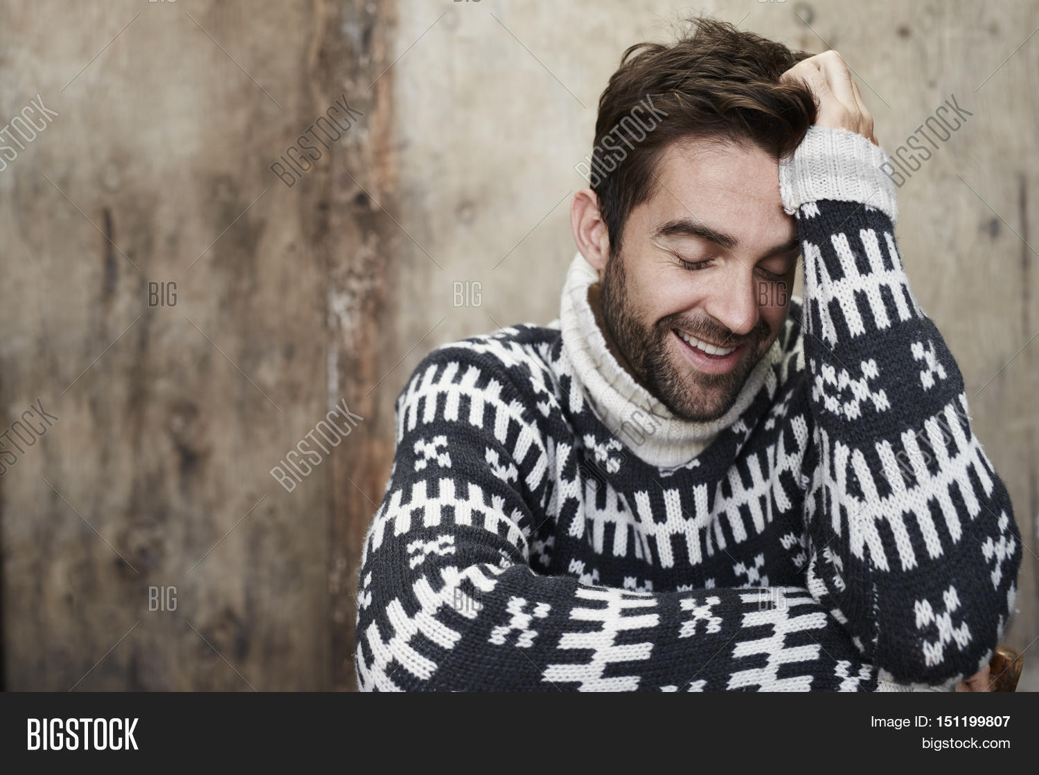 man laughing in knitted sweater in studio