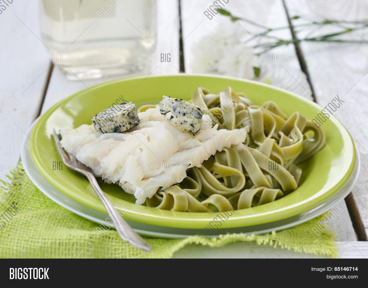 codfish fillet and pasta on the green plate