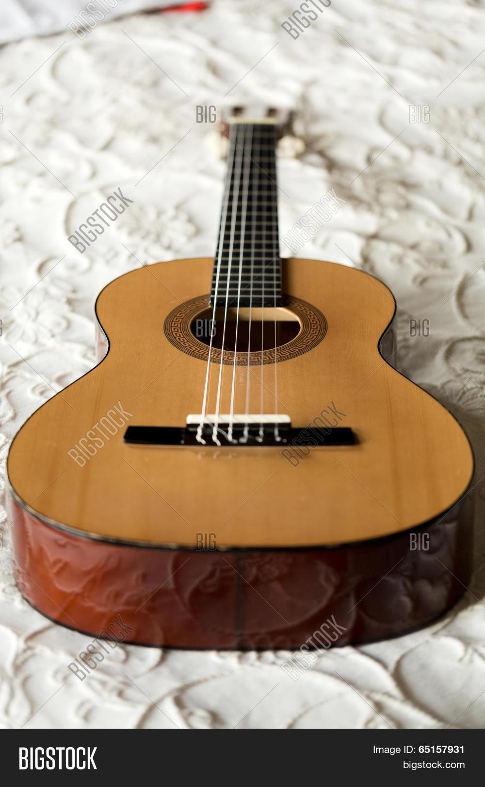 close up of spanish guitar lying on the bed ** note: shallow