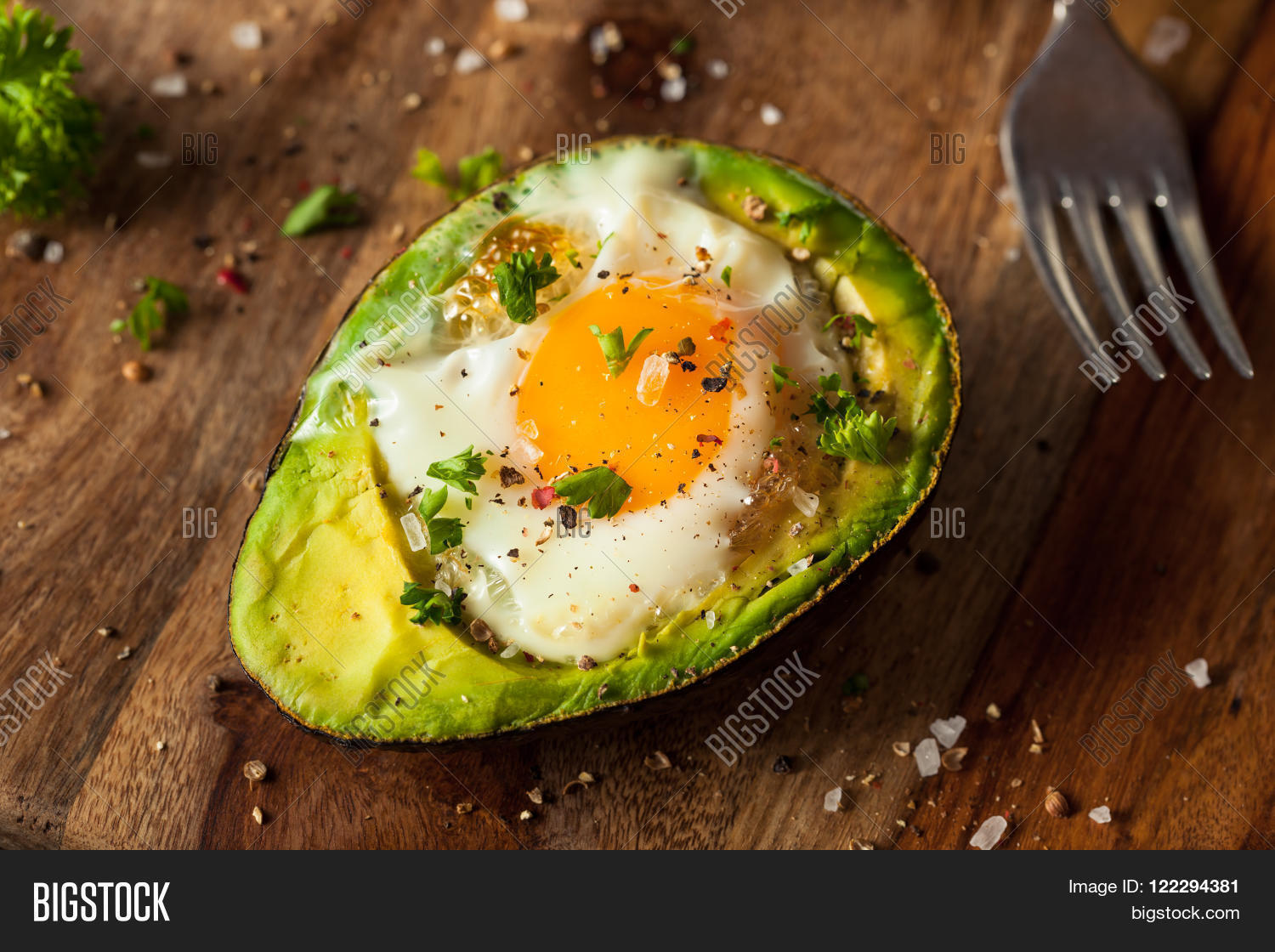 homemade organic egg baked in avocado with salt and pepper