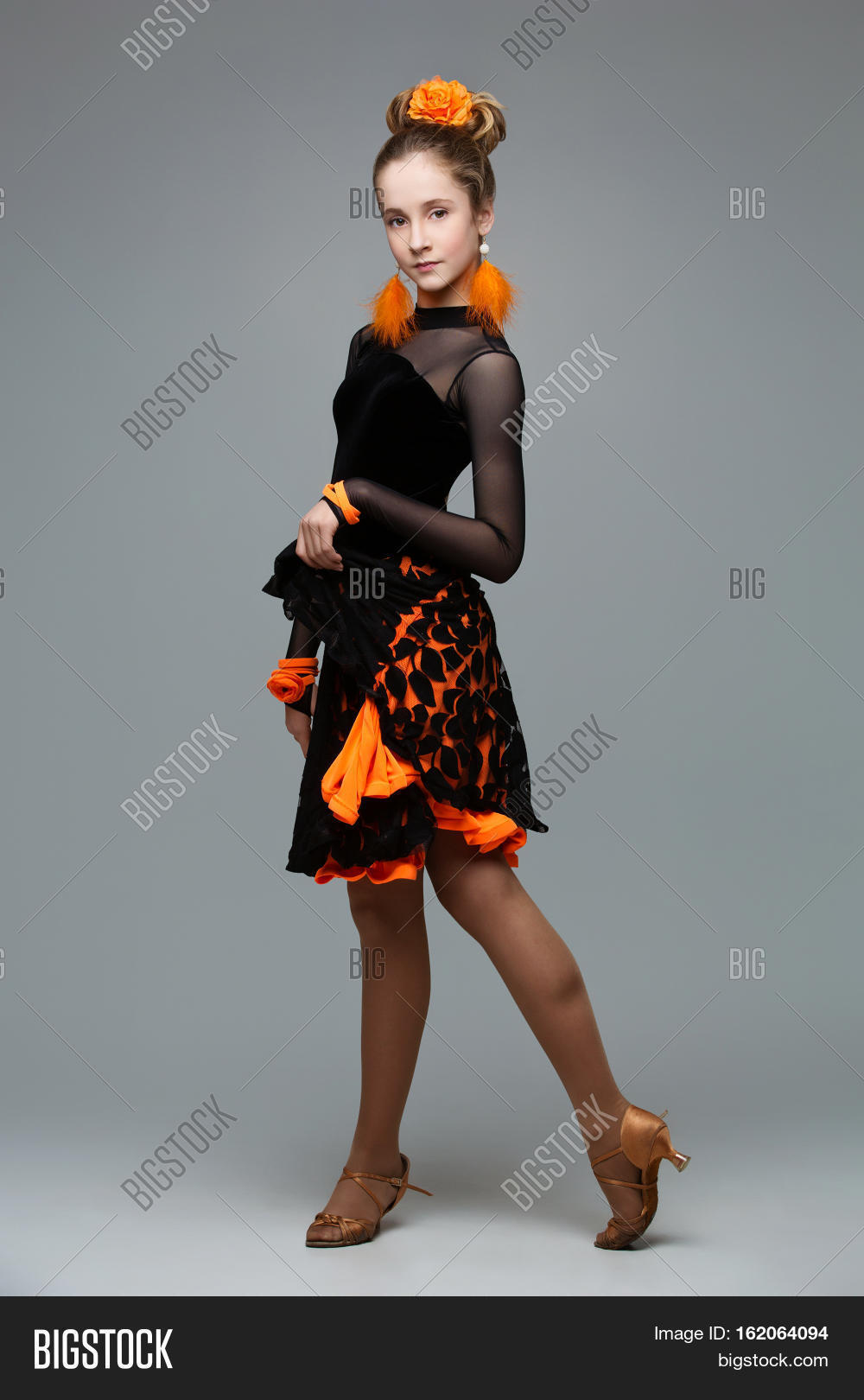 beautiful teenage ballroom dancer girl in black and orange