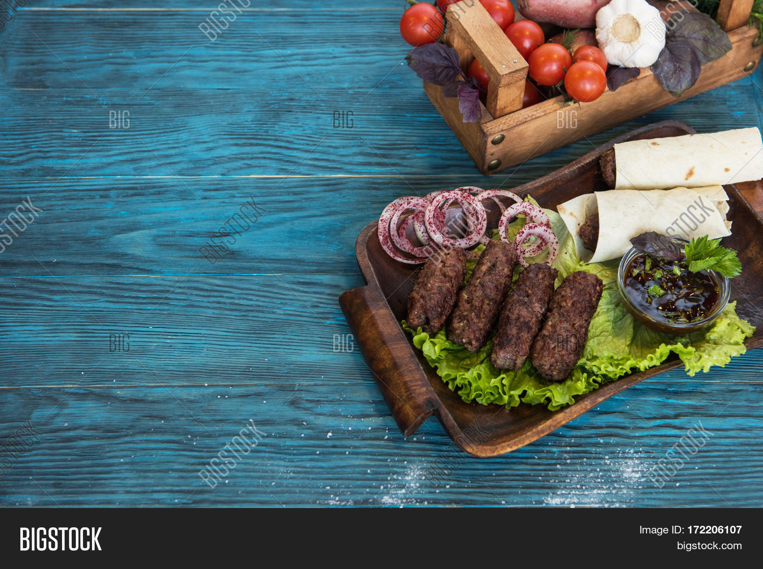 grilled lula kebab - meat dish, with vegetable on a blue wooden