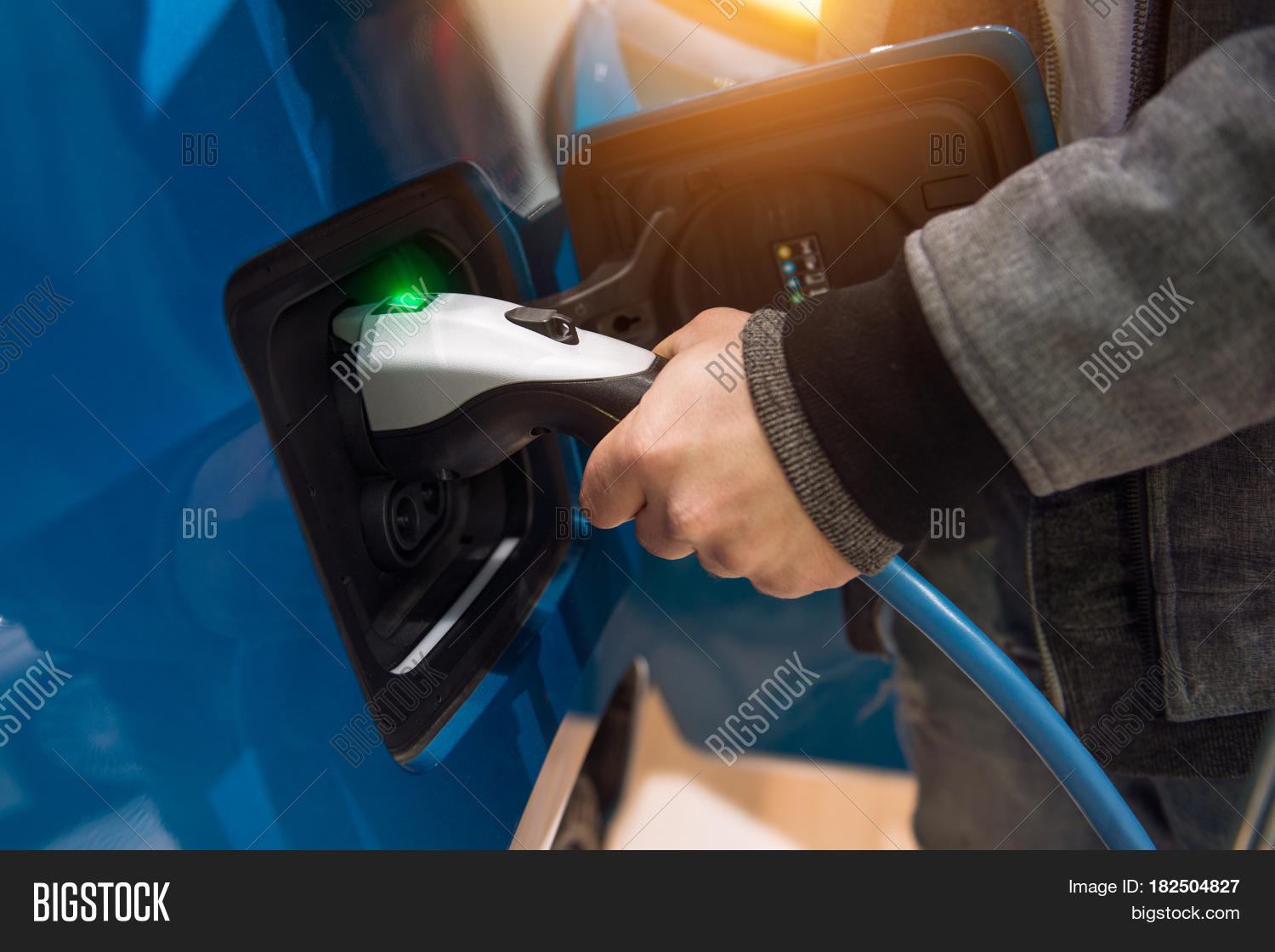 man charging electro car at charging station.