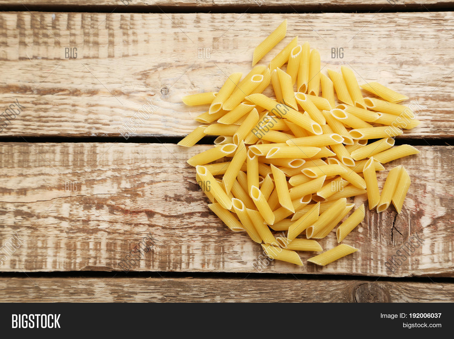 pasta penne on the brown wooden table