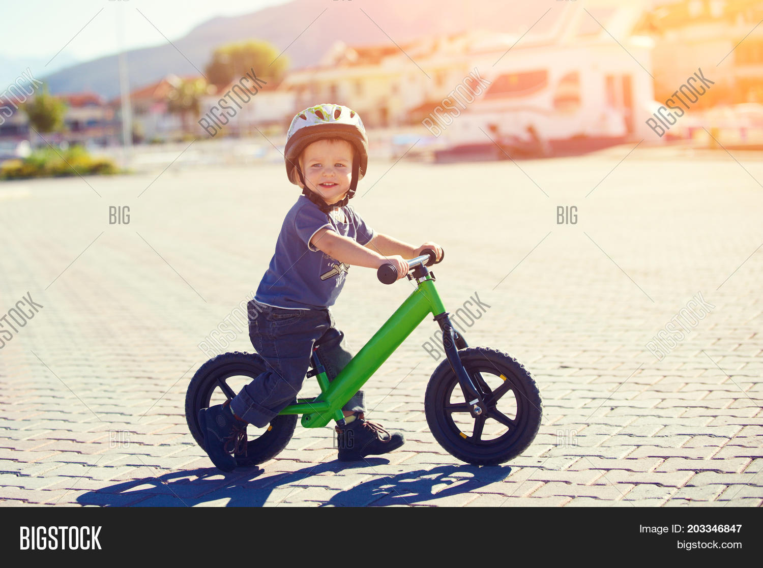 little boy riding a runbike on a sunny day