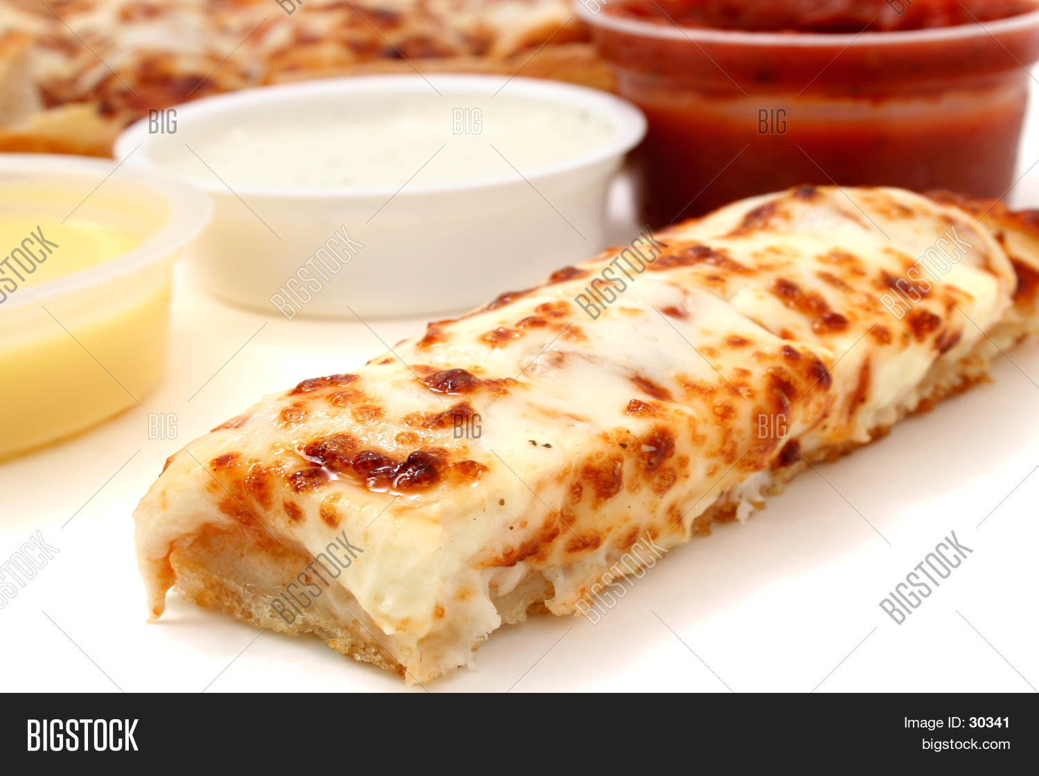 cheese pizza sticks with a container of marinara sauce, ranch
