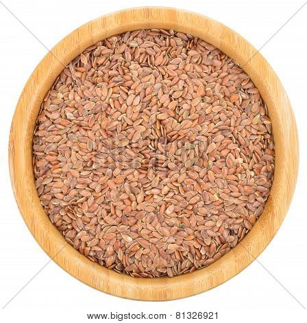 brown flax seeds in wooden bowl isolated.
