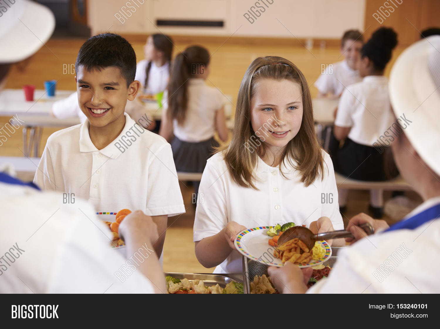 over shoulder view of kids being served in school cafeteria
