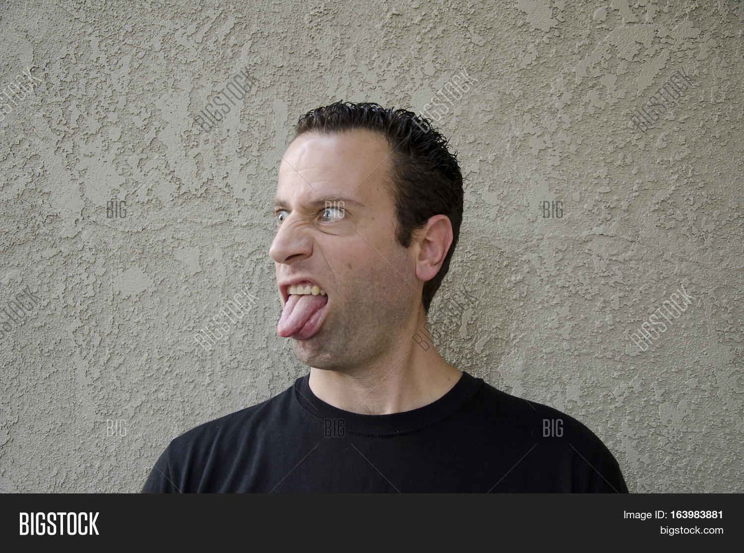 funny face - man sticking his tongue out off to the left side.