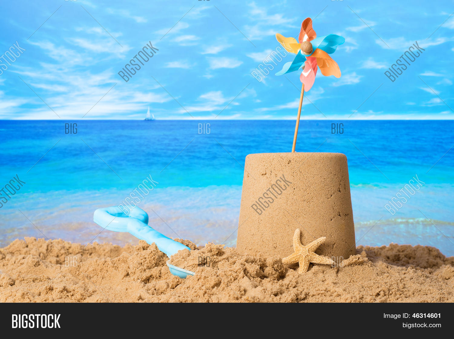 sandcastle with windmill on summer beach