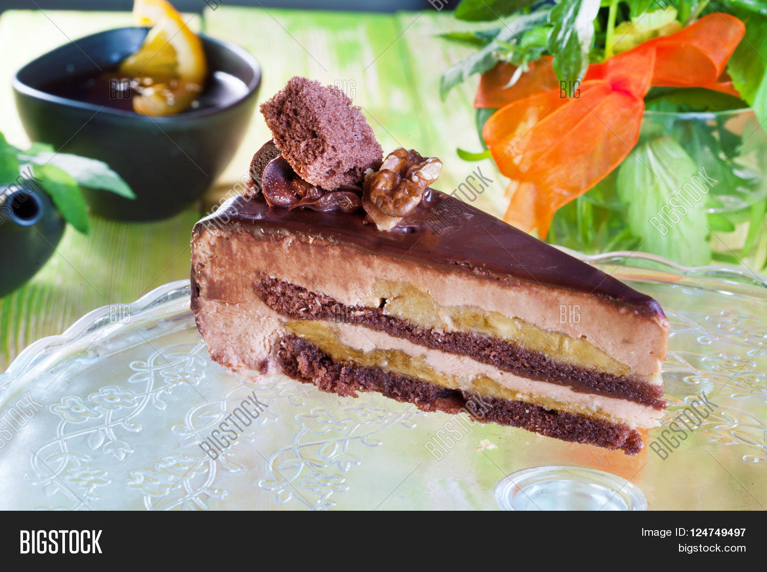 glazed chocolate cake with banana and walnuts, piece, still life