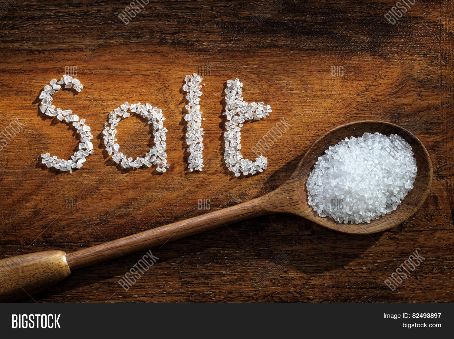 sea salt on wooden spoon and the word salt written in grain