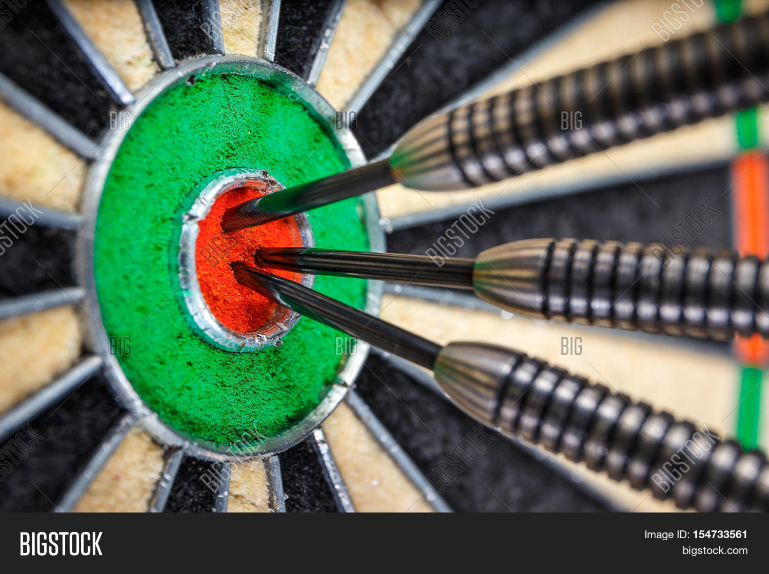 three darts in bulls eye close up