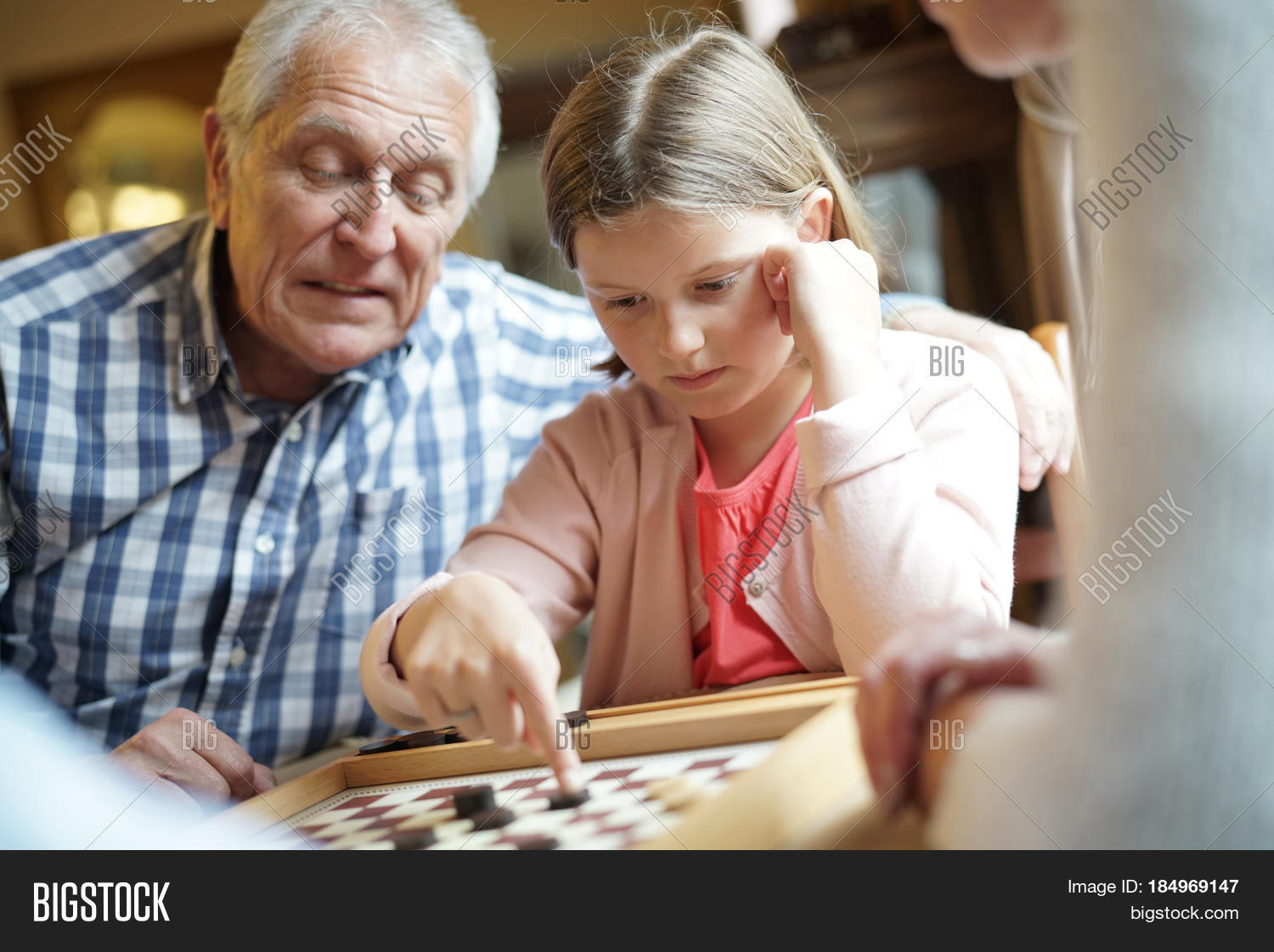 grand-parents with grandkids playing checkers