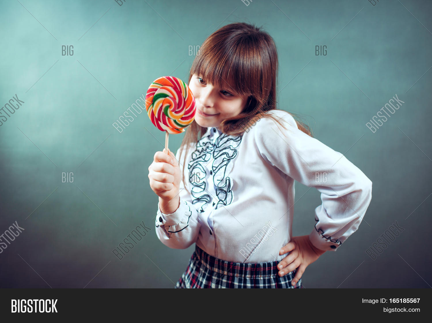 6 or 7 years old child girl eating big multicolor spiral