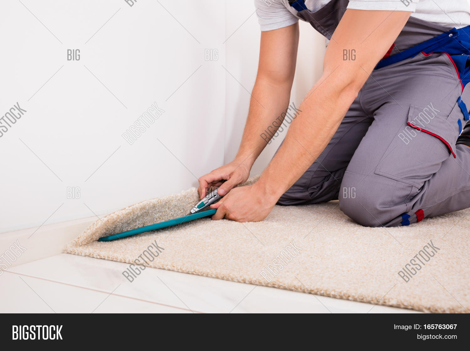 close-up of a craftsman fitting carpet on floor with cutter