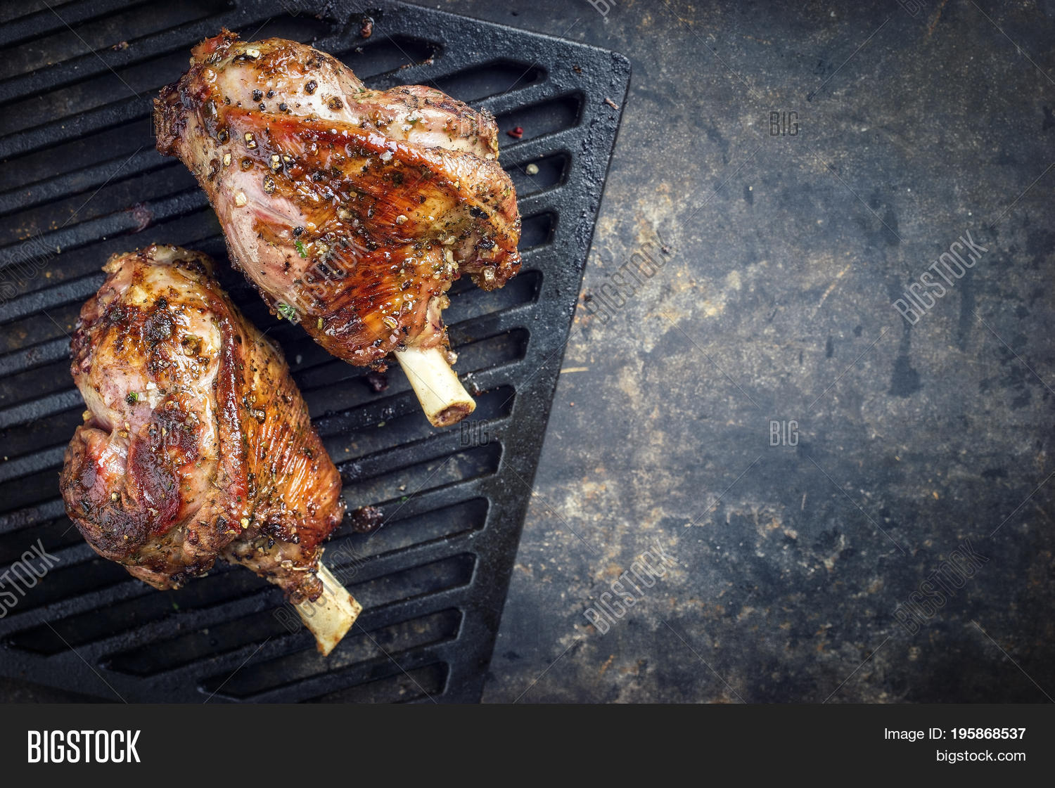 two barbecue leg of lamb as top view on cast iron grillage