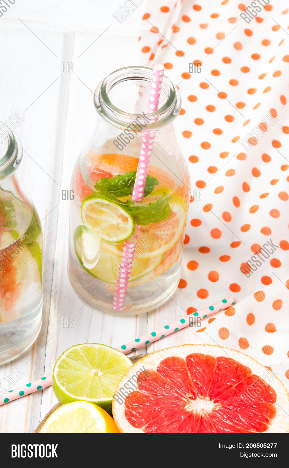 infused flavored water with fresh fruits on white wooden back