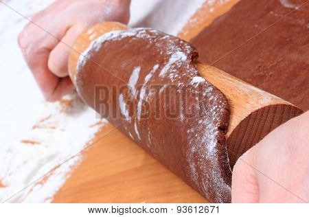 hand with rolling pin kneading dough for gingerbread