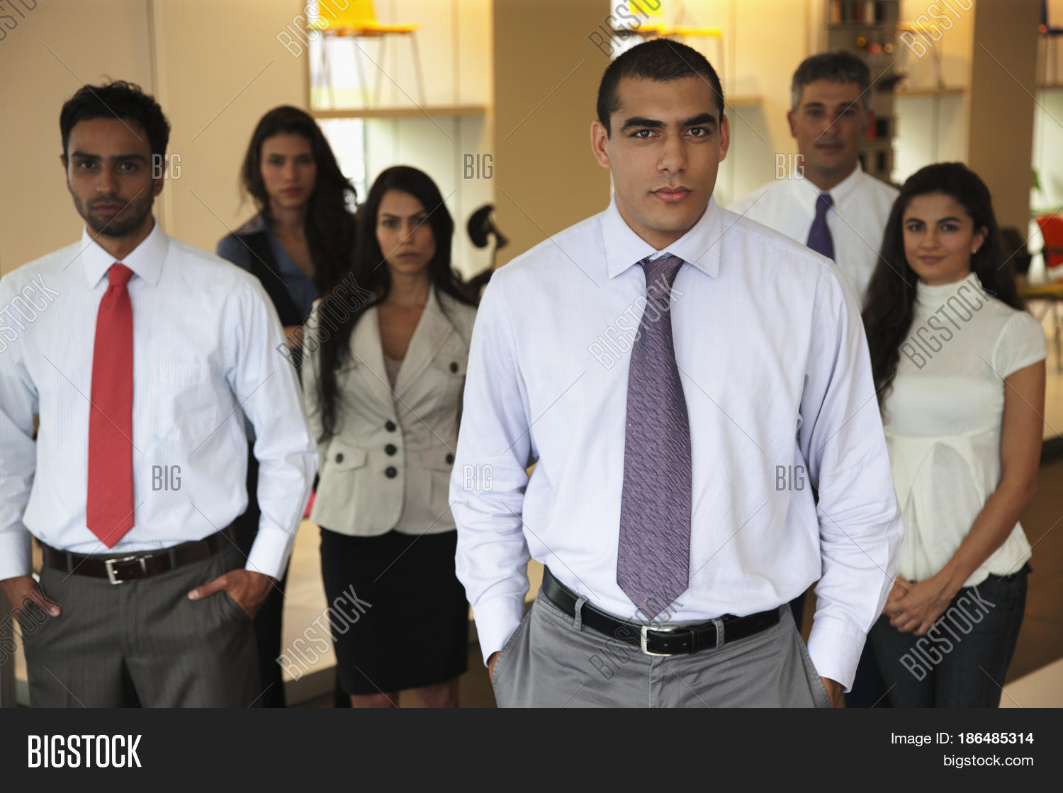 smiling hispanic business people standing together in office