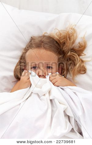 小女孩有童年的噩梦和恐惧躲在被子里下