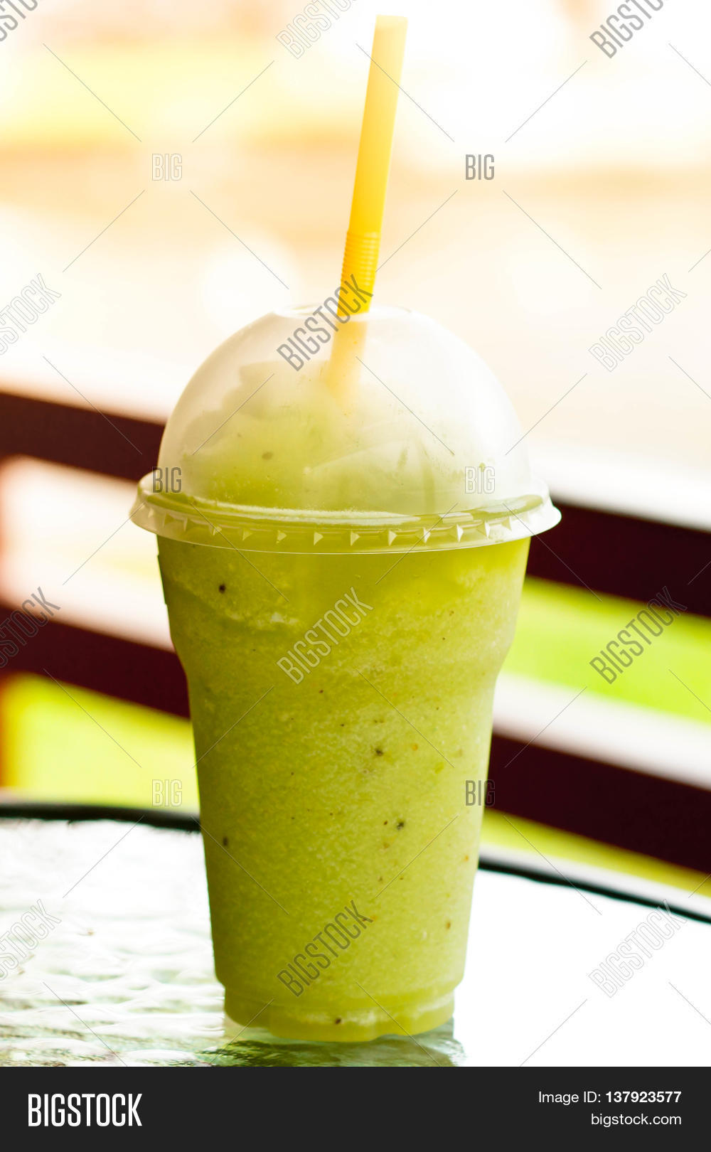 kiwi juice in a plastic glass / kiwi smoothie