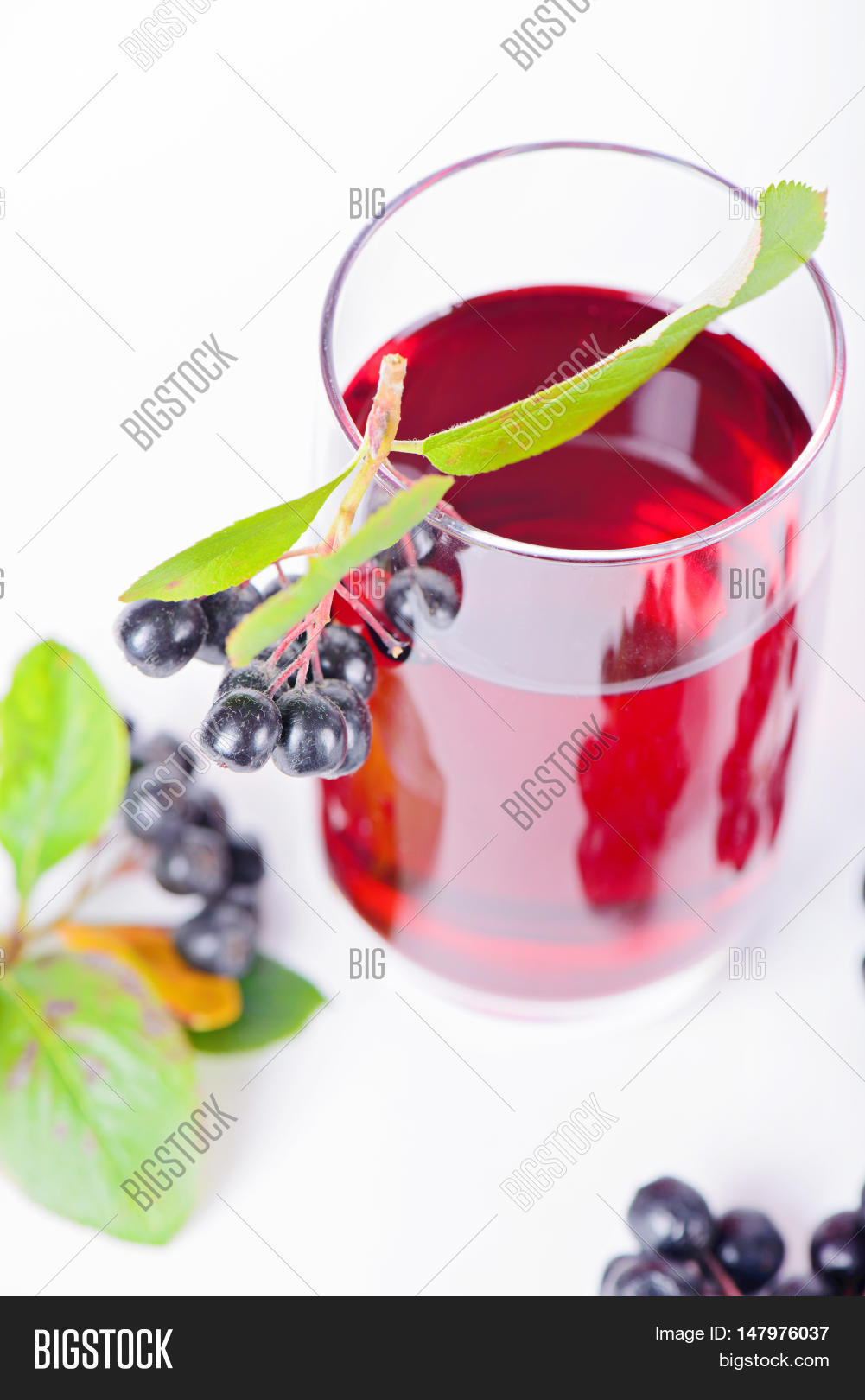 glass of aronia juice with berries in the light background