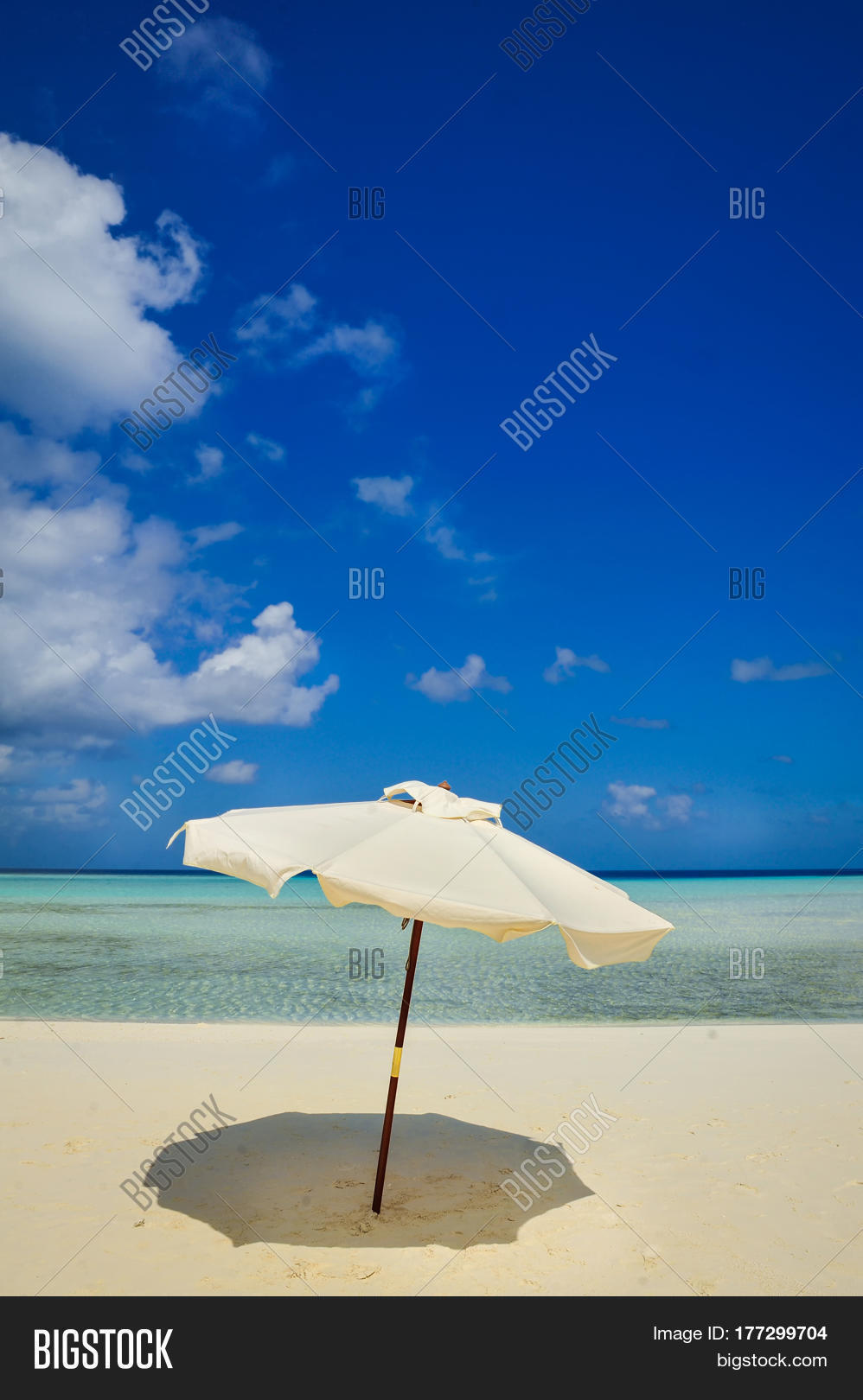 white beach umbrella and blue sky.sun and umbrella on the beach.