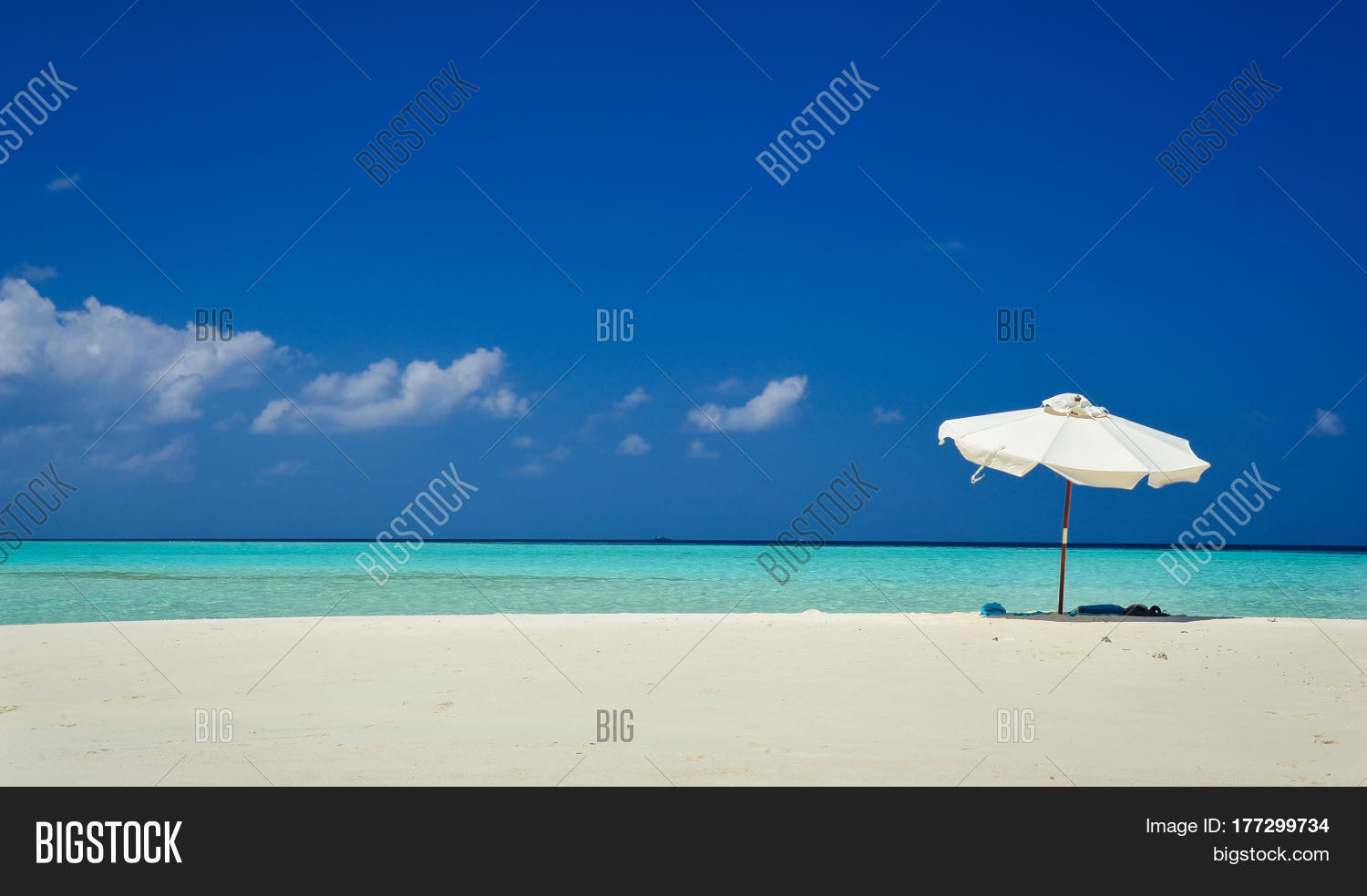 white beach umbrella and blue sky.sun and umbrella on the beach.
