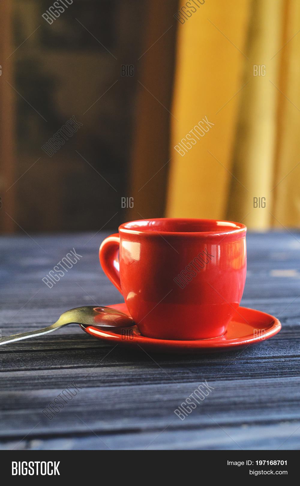 a cup of red espresso on a wooden table in the cozy interior of