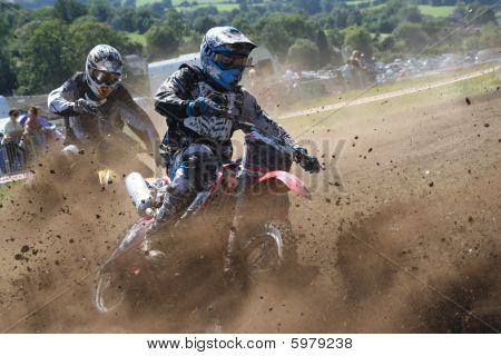 Dirt Bikes battle the corner in a cloud of mud : Bigstock