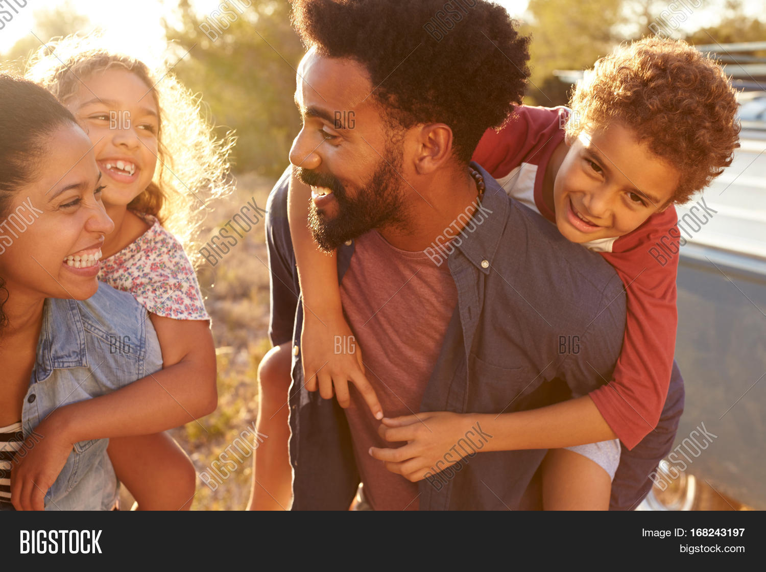 parents giving their kids piggybacks, waist up, close up