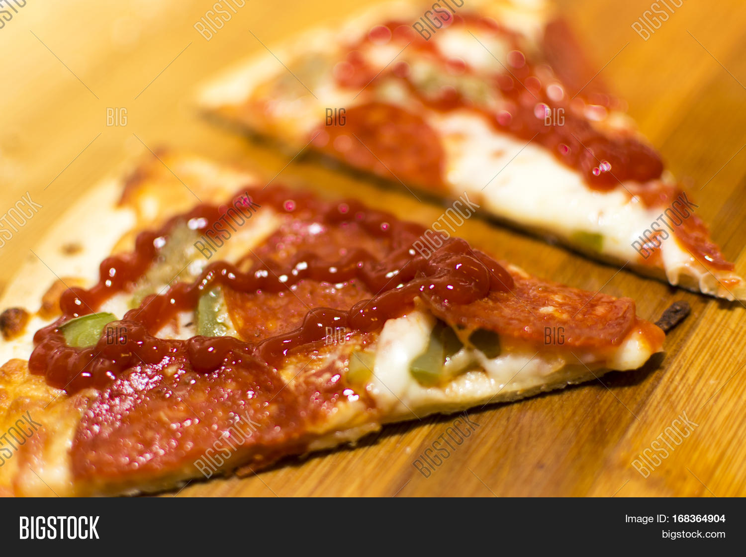 a shot of a freshly baked pepperoni pizza with ketchup on top.