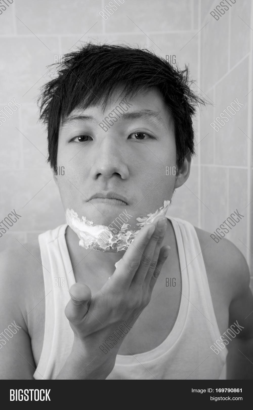 portrait of mid adult man applying shaving foam on face in