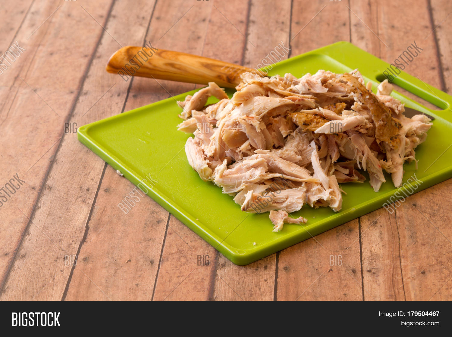 shredded rotisserie chicken on a green plastic cut