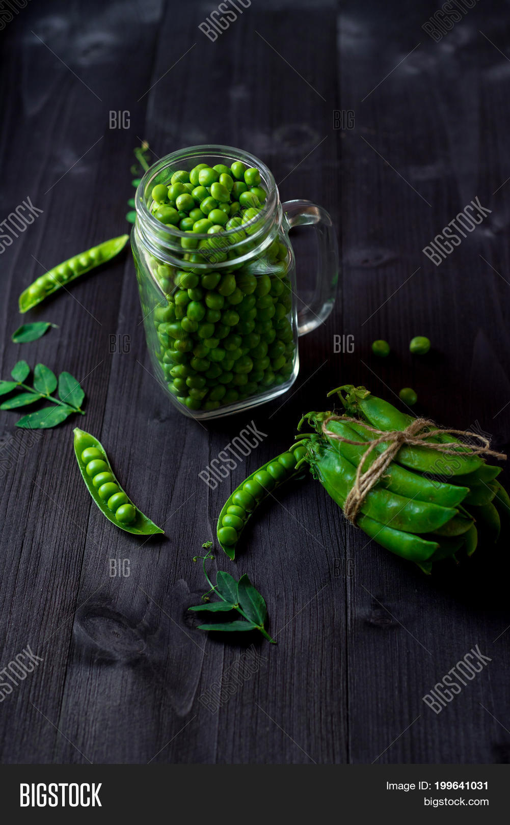bunch of fresh mature pods of green peas tied with a rope near
