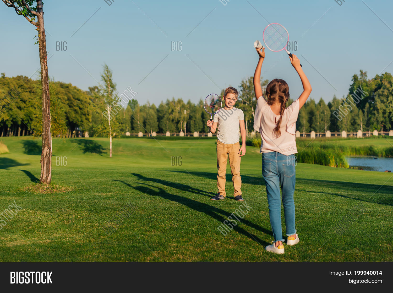 little children playing badminton together in park